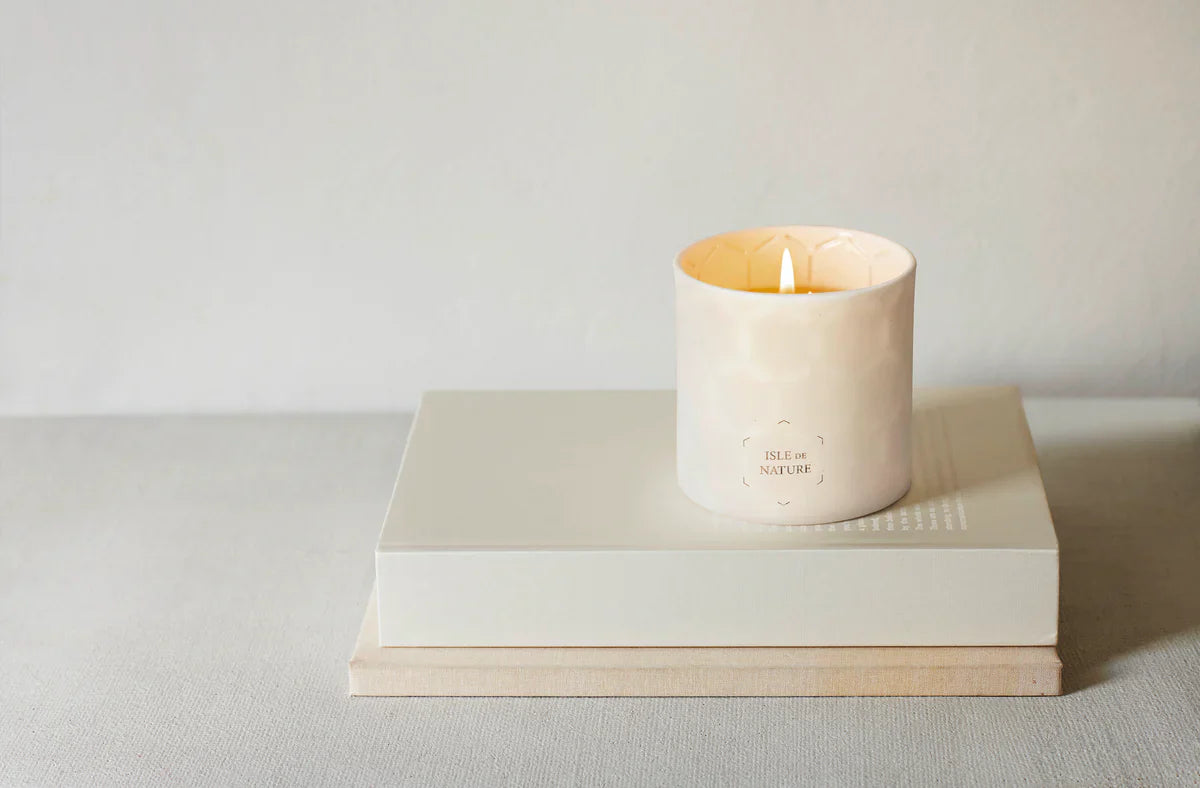 Isle de Nature beeswax candle with luxury packaging on neutral island-inspired backdrop