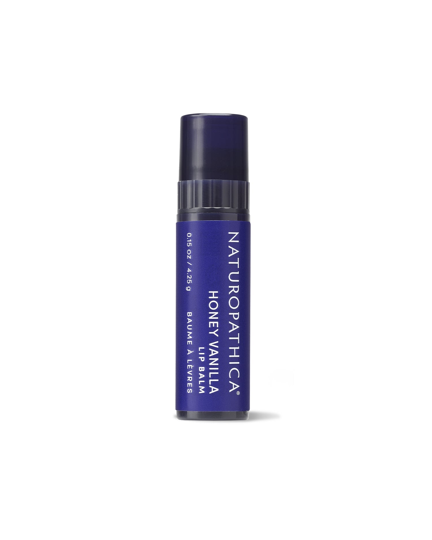 Tube of Naturopathica Soothing Honey Vanilla Lip Balm on a neutral surface with honey dipper and vanilla bean, styled for nourishing daily lip care