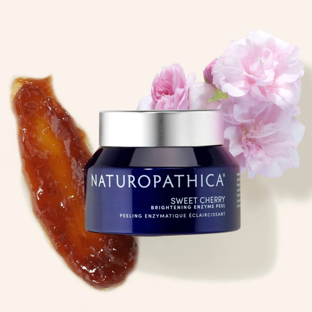 Naturopathica Sweet Cherry Brightening Enzyme Peel with cherries and botanicals in a spa-inspired flat lay