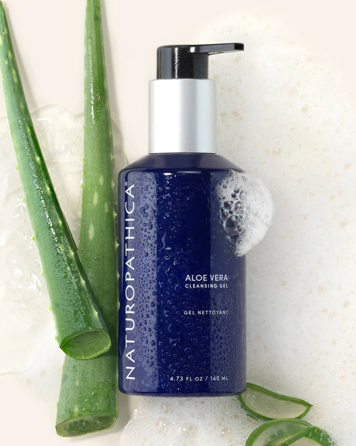 Bottle of Naturopathica Aloe Vera Cleansing Gel placed beside aloe leaves and a clean towel, styled as a calming daily facial cleanser

