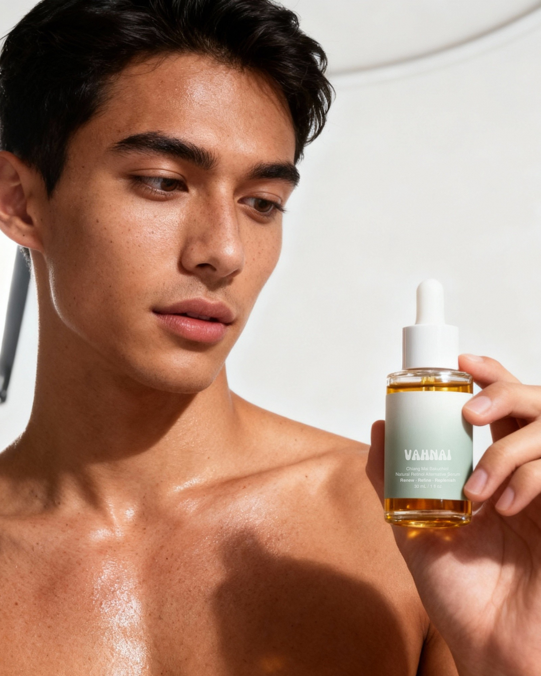 Man holding a bottle of Vamia skincare product against a neutral background